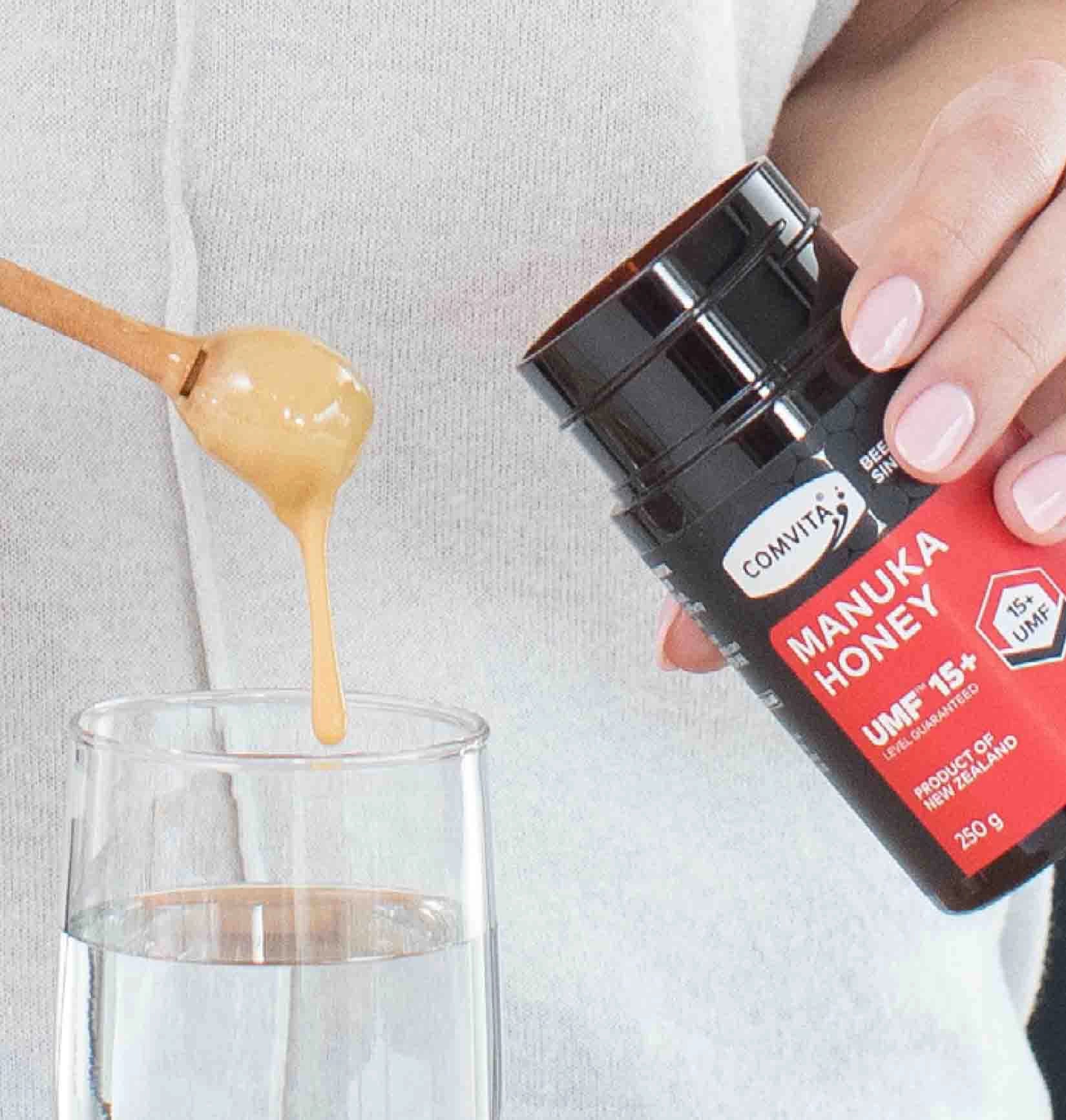 manuka honey being added to water for a health tonic