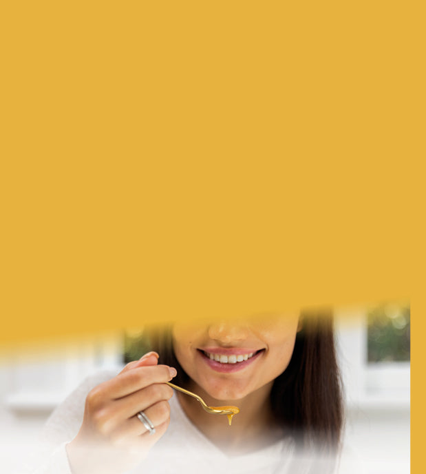 woman taking manuka honey directly from a spoon