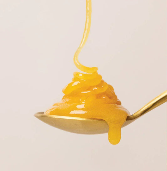 Manuka honey dripping into a spoon